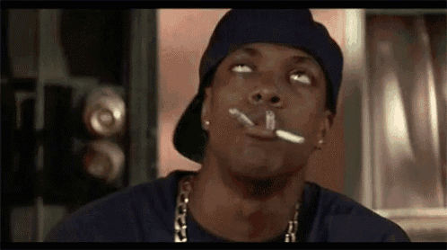 a man in a hat is smoking a cigarette in a room .