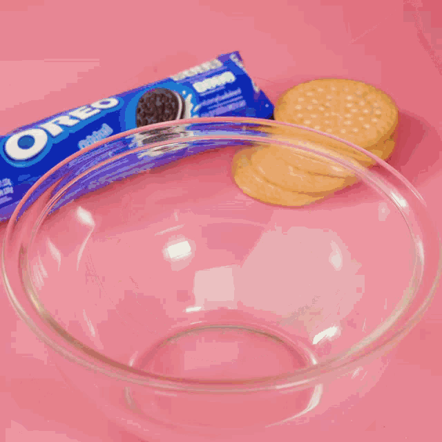 a bowl of cookies next to a package of oreo cookies