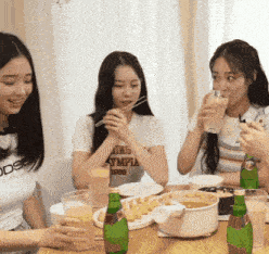 a girl wearing a t-shirt that says adidas sits at a table with other girls