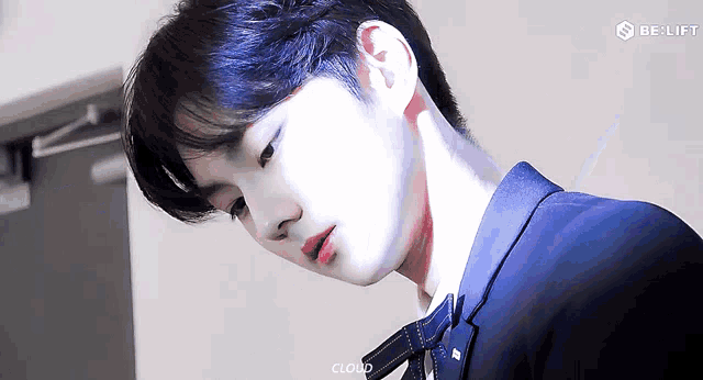 a young man in a suit and tie is looking down