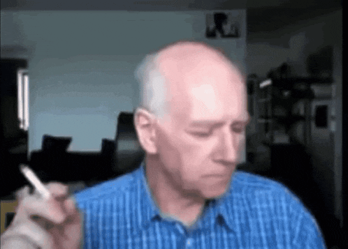 a bald man smoking a cigarette in a blue shirt