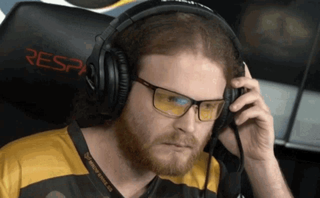 a man wearing glasses and headphones is sitting in a chair with a resp logo on the back