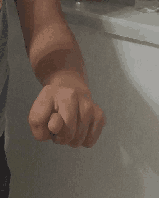 a close up of a person 's fist against a wall