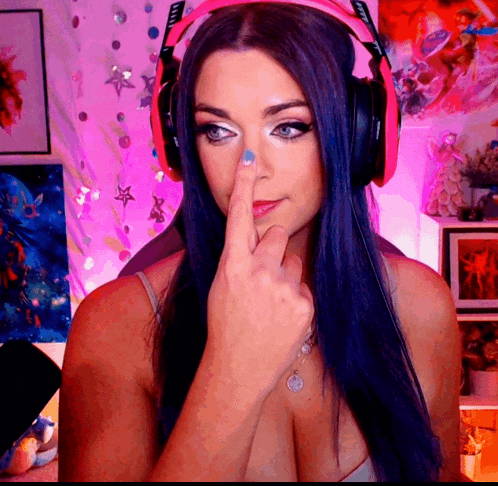 a woman with blue hair and headphones is making a face