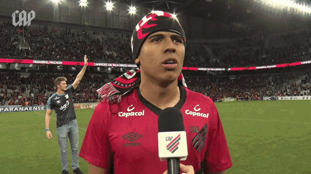 a man in a red shirt with copacol on it