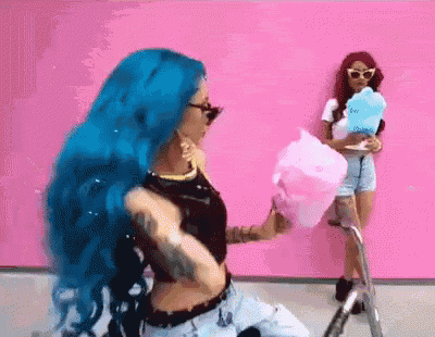 a woman with blue hair is eating cotton candy while another woman holds a plate of cotton candy .