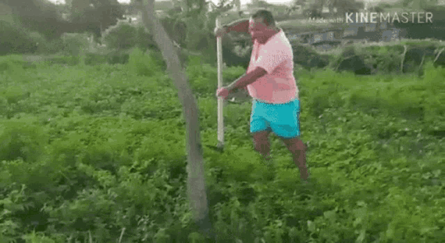 a man is standing in a field holding a spear .