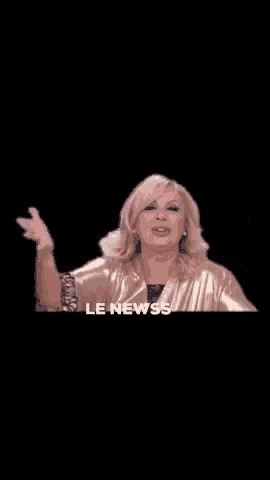 a woman in a gold dress is talking into a microphone and says le news .
