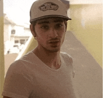 a man wearing a white t-shirt and a white hat with the word vans on it