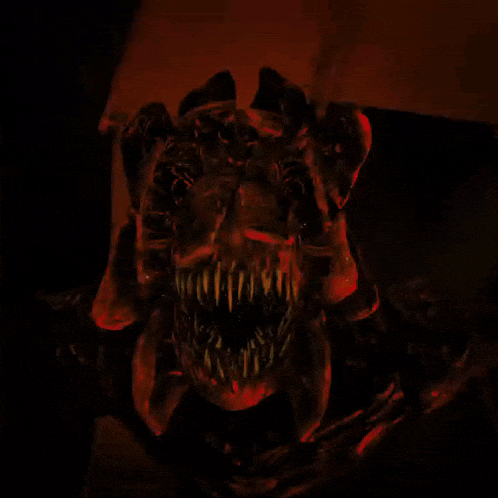 a close up of a monster 's face with sharp teeth and horns
