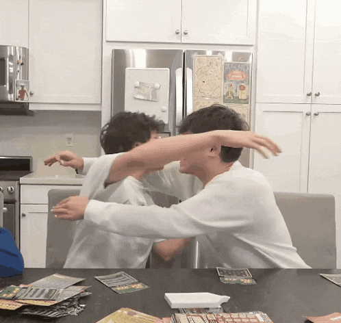 two men are playing a game in front of a refrigerator with a sticker on it that says ' lucky '