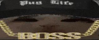 a close up of a person wearing a necklace that says boss .