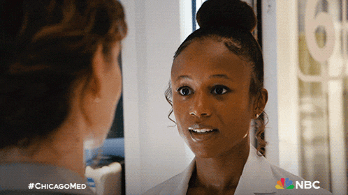 a woman in a white lab coat is talking to another woman with #chicagomed on the bottom