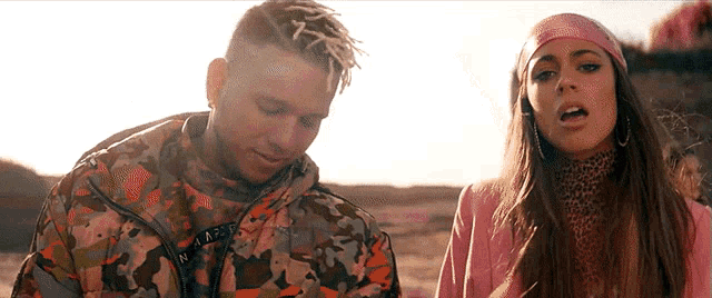 a man and a woman are standing next to each other and the man has dreadlocks