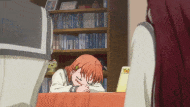 a girl laying on a table in front of a bookshelf with a book that says ' a ' on it