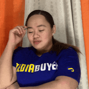 a woman wearing a blue t-shirt that says ' diabuyer ' on it