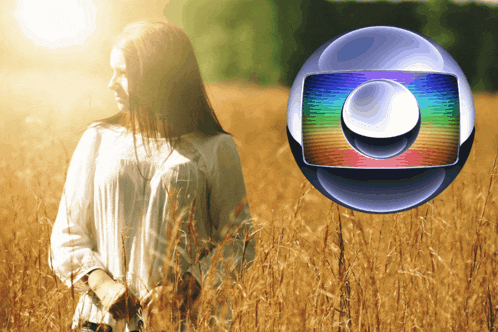 a woman stands in a field of tall grass with a globe in the background