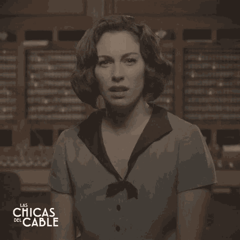 a woman stands in front of a wall with the words las chicas del cable written on it