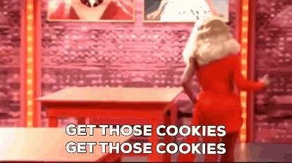 a woman in a red dress is standing in front of a table with the words " get those cookies get those cookies "