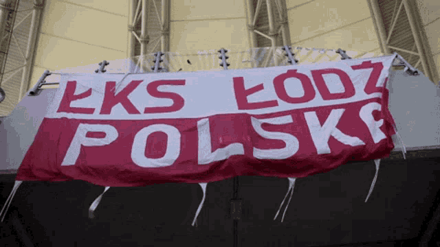 a red and white banner that says ' eks lodz polska ' on it