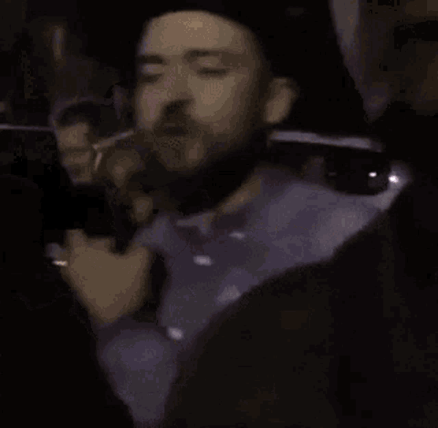 a man in a cowboy hat is driving a car in a dark room .