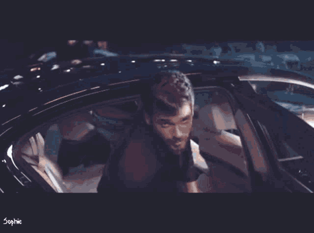 a man is getting out of a car with the word sophie on the bottom