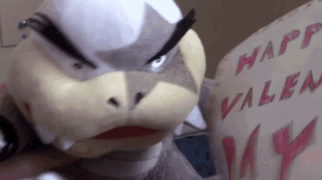 a stuffed animal is holding a valentine 's day card that says happy valentine 's day