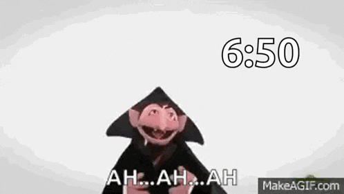 a close up of a sesame street character wearing a black hat and a black robe .