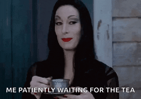a woman in a black dress is holding a cup of tea and says `` me patiently waiting for the tea '' .