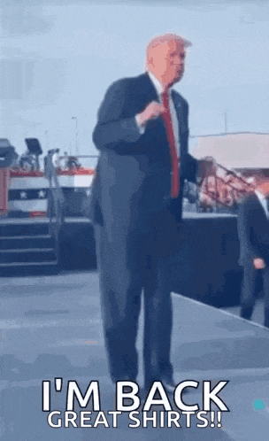 a man in a suit and tie is standing on a stage and dancing .