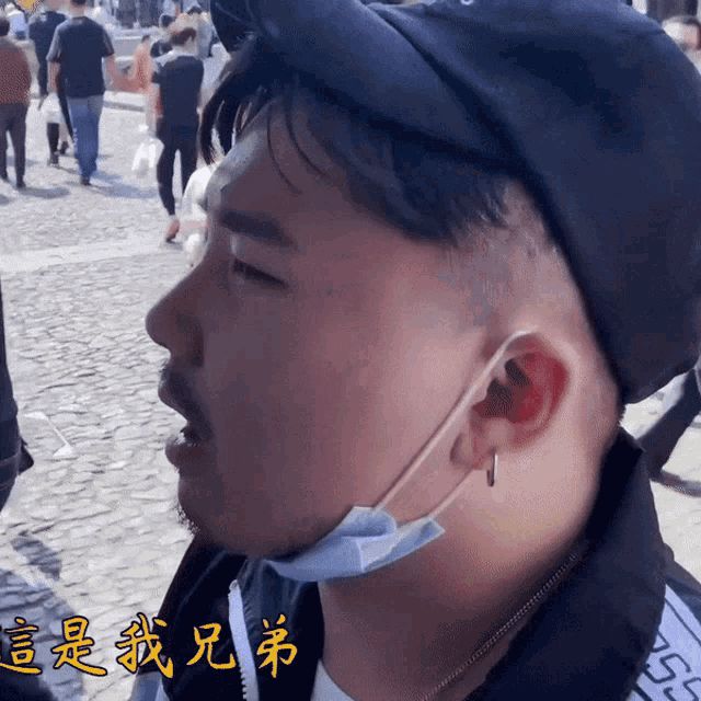 a man wearing a hat and a face mask has chinese writing on his face