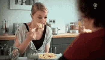 a woman is sitting at a table with a plate of food in front of her and a sign that says ' salz '