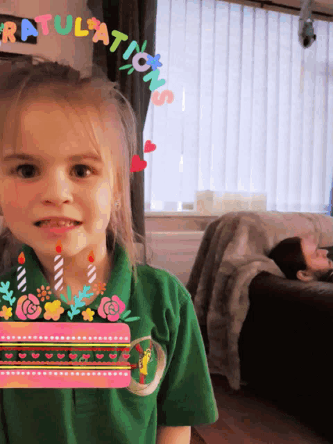 a little girl in a green shirt holds a birthday cake with candles