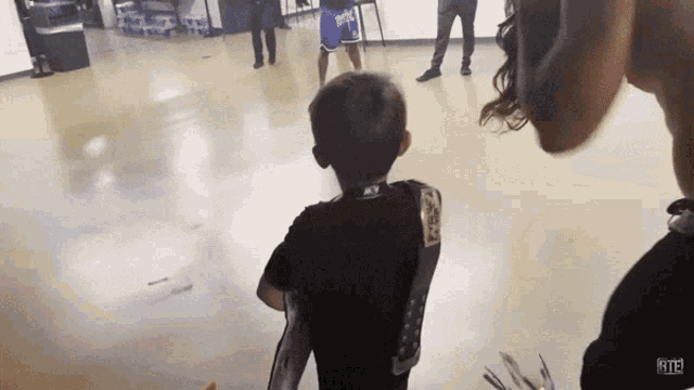 a little boy wearing a black shirt with a sticker on it that says ' r113 ' on it