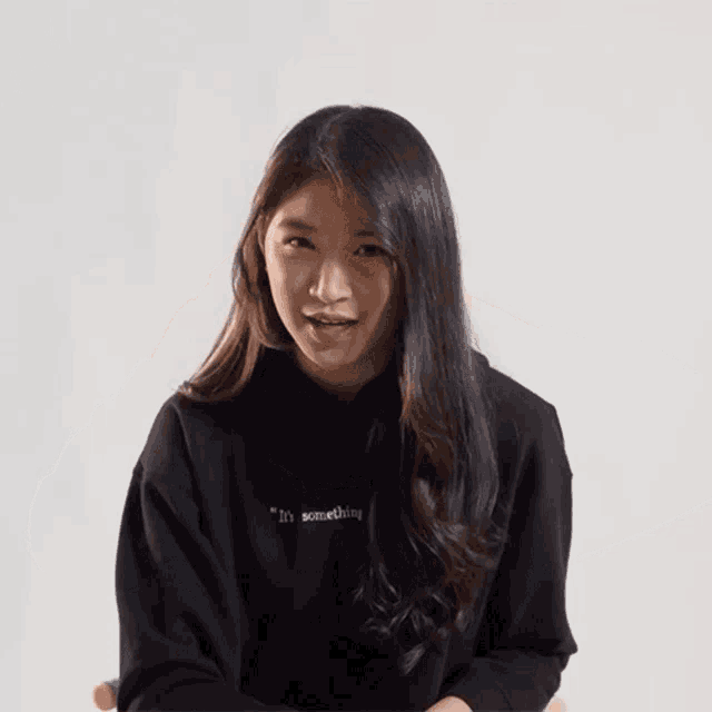 a girl wearing a black sweatshirt that says something on it