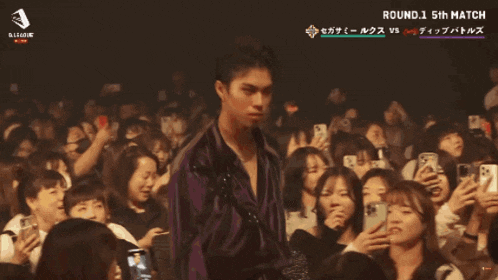 a man stands in front of a crowd that says hibiki on the bottom