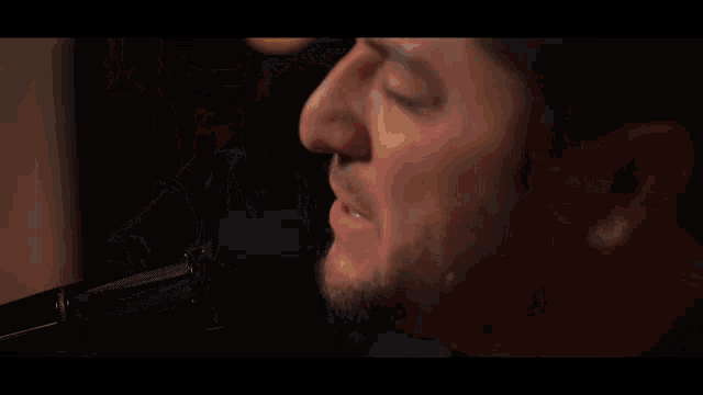 a man singing into a microphone with a beard