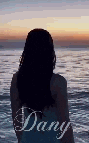 a woman is standing in front of the ocean with the name dany written on the bottom