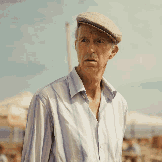 an elderly man wearing a hat and a striped shirt