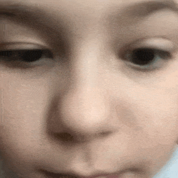 a close up of a child 's face with a slight smile .