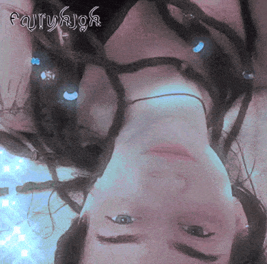 a woman with dreadlocks is laying upside down with the word fairyhigh above her head
