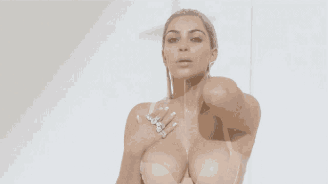 a naked woman is taking a shower with her breasts visible