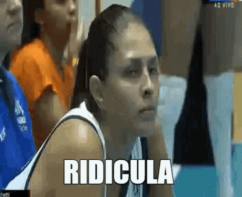 a woman is sitting in a crowd with the word ridicula written on her face
