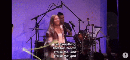 a woman singing into a microphone with the words let everything that has breath praise the lord