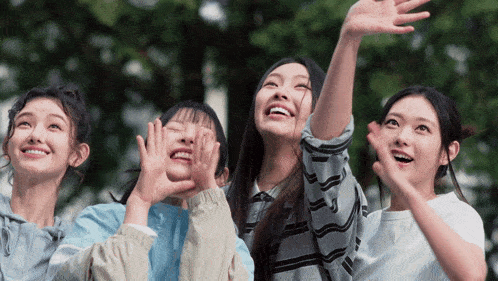 a group of young women are smiling and looking up at the sky