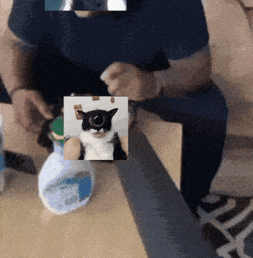 a man sitting on a couch holding a picture of a cat