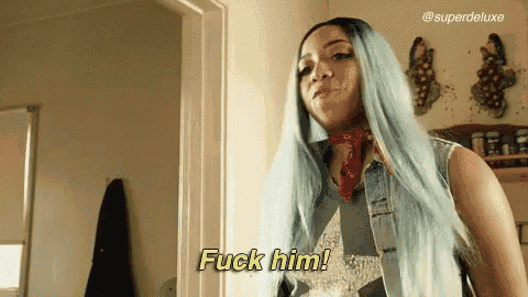 a woman with blue hair is standing in a doorway and says fuck him .
