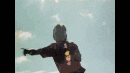 a silhouette of a man with his arms outstretched in front of a cloudy sky