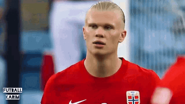 a close up of a soccer player wearing a red jersey