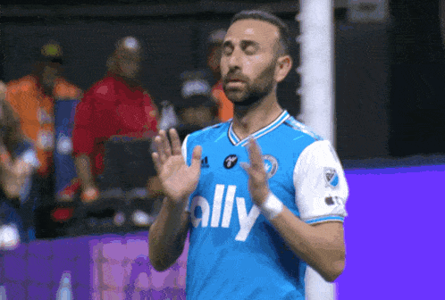 a soccer player wearing a blue shirt that says ally